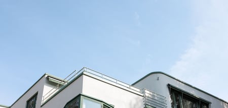 Vitt flerbostadshus mot blå himmel